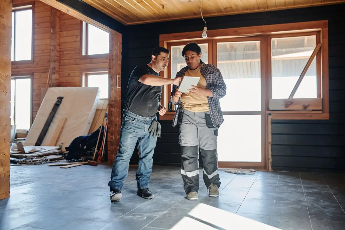 Two contractors reviewing renovation plans inside a house in Kyle, TX